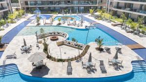 una vista aérea de una piscina con mesas y sillas en A melhor vista do Malia Beach - Flat 205C, en Ipojuca 37 fotos más