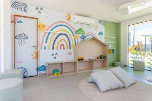 Habitación infantil con un mural de arco iris en la pared en A melhor vista do Malia Beach - Flat 205C, en Ipojuca