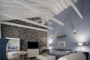 a living room with a couch and a stone wall at Pico Boutique House in Lajes do Pico
