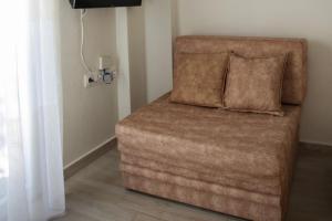 a brown couch with two pillows sitting in a room at 4Keys Apartments Nikiti in Nikiti +56 photos