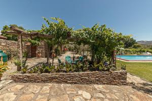 a garden with a pergola and a swimming pool at Casinha da horta in Mirandela