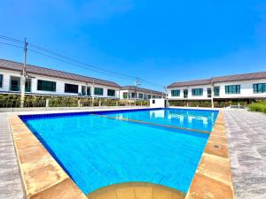 a large blue swimming pool in front of a building at Chokchai village 9 in Nong Prue
