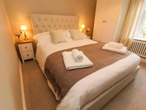 a bedroom with a large bed with towels on it at The Cobbles in Skipton