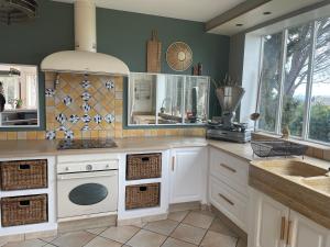 a kitchen with white cabinets and a stove top oven at Villa Notre-Dame avec piscine in Rochefort-du-Gard