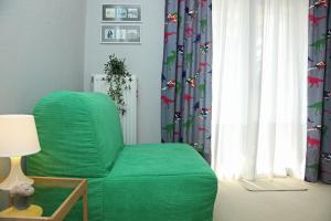 a living room with a green chair and a window at Artistic elegant home in Afitos