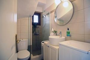 a bathroom with a sink and a toilet and a mirror at Artistic elegant home in Afitos +49 photos