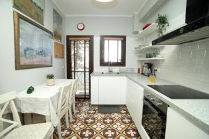a kitchen with a table and a kitchen with white cabinets at Artistic elegant home in Afitos