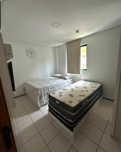 a room with two beds in it with a window at Marulhos Resort in Porto De Galinhas