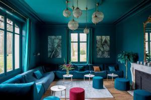 a living room with blue furniture and windows at Les Hayes en Sologne - Proche Chambord in Fontaines-en-Sologne