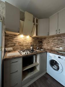eine Küche mit einem Herd und einer Waschmaschine in der Unterkunft Luxury apartment Slobozhansky Prospekt in Nizhnedneprovsk + 2 Fotos