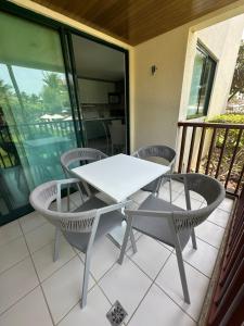 a white table and chairs on a balcony at Marulhos Resort in Porto De Galinhas
