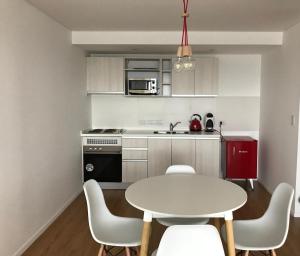 a kitchen with a white table and chairs in a room at Costa Beagle in Ushuaia