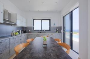 a kitchen with a large wooden table and chairs at Luxury Villa Apeiro in Plaka in Plaka
