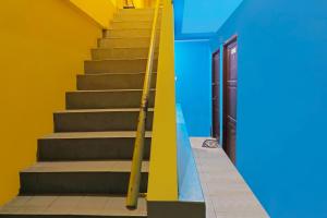 un escalier avec des murs bleus et jaunes et une porte dans l'établissement Hotel O Pelangi House 789 Syariah, à Nagoya