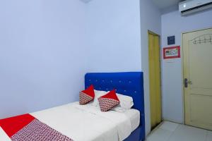 une chambre avec un lit avec des oreillers rouges dessus dans l'établissement Hotel O Pelangi House 789 Syariah, à Nagoya