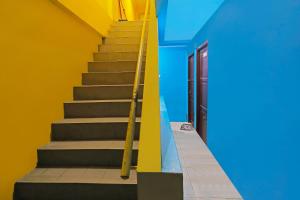 un escalier avec des murs bleus et jaunes et une porte dans l'établissement Hotel O Pelangi House 789 Syariah, à Nagoya