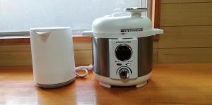 a coffee maker and a cup on a table at 泉崎荘 in Naha