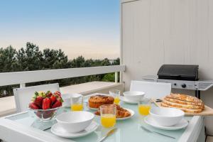een tafel met eten en fruit op een balkon bij Ocean Bliss - Beach & BBQ Apartment in Viana do Castelo