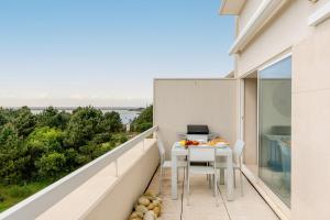 een balkon met een tafel en een computer erop bij Ocean Bliss - Beach & BBQ Apartment in Viana do Castelo