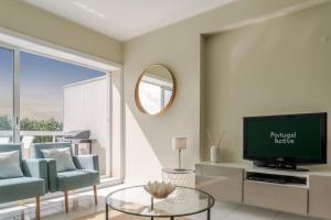 een woonkamer met een tv en een bank bij Ocean Bliss - Beach & BBQ Apartment in Viana do Castelo +53 foto's