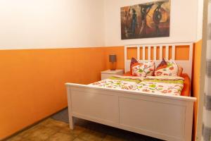 a bed in a room with orange and white walls at Ferienwohnung Mit Balkon Und Geschirrspülmaschine in Weißenstadt +30 photos