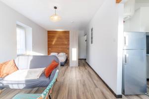 a living room with a couch and a refrigerator at Le Cosy in Tournon-sur-Rhône
