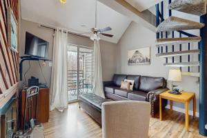 a living room with a couch and a tv at Summit Splendor in Gatlinburg