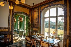 a dining room with tables and a large window at Le Petit Château Peltzer in Verviers