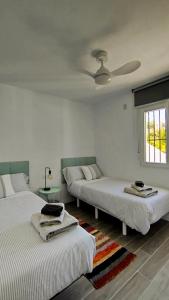ein Schlafzimmer mit zwei Betten und einem Deckenventilator in der Unterkunft Naranjos House in Muntanya la Sella + 25 Fotos