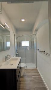 ein Badezimmer mit Dusche, Waschbecken und Toilette in der Unterkunft Naranjos House in Muntanya la Sella