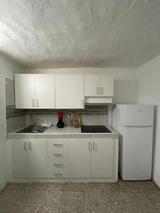 a kitchen with white cabinets and a white refrigerator at Casa ADOLFO in Almáciga