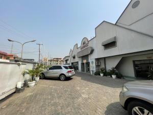 un'auto parcheggiata in un parcheggio di fronte a un edificio di Presken Hotel (Reliance) a Ikeja
