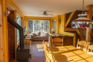 a living room with yellow walls and a wood stove at Chalet Massif domaine Multibois in Petite-Rivière-Saint-François