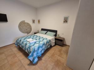 a bedroom with a bed with a blue and white comforter at Drin room in Catanzaro Lido