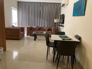 a living room with a table and chairs and a couch at Uptown Hotel Apartment in Amman