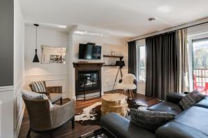 a living room with a couch and a fireplace at Condo Luxueux au pied du Mont in Saint-Sauveur-des-Monts