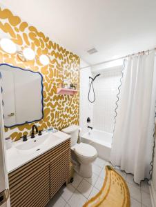 Un baño con lavabo, inodoro y cortina de ducha. en The Venturi Suite 1 King, en Columbia