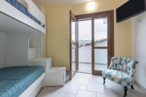 a bedroom with a staircase and a bed and a chair at GuestHost - Domus Ritae in Domus de Maria