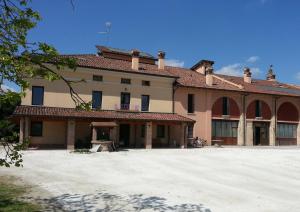 una casa grande con una gran entrada de entrada frente a ella en B&B La Viola, en Castelvetro Piacentino