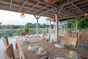 - une salle à manger avec une table et des chaises en bois dans l'établissement Kememai Hostel, à Ubud