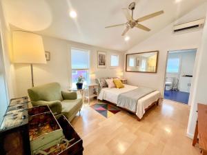 a bedroom with a bed and a couch and a tv at East Side Blue Bonnet Cottage in Austin