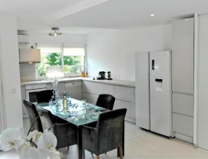 eine Küche mit einem Tisch mit Stühlen und einem Kühlschrank in der Unterkunft Terrasse de Malissol in Vienne + 9 Fotos