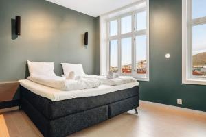 a bed with teddy bears on it in a room with windows at DINBNB Apartments l Luxury Penthouse l Roof Terrace l Central Bergen in Bergen