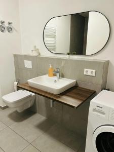 ein Badezimmer mit Waschbecken, Toilette und Spiegel in der Unterkunft Modernes Business-Apartment, 2 Zimmer, zentrale Lage in Hamburg in Hamburg