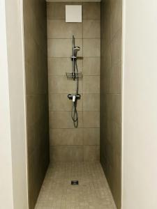 eine Dusche mit einem Schlauch im gefliesten Bad in der Unterkunft Modernes Business-Apartment, 2 Zimmer, zentrale Lage in Hamburg in Hamburg