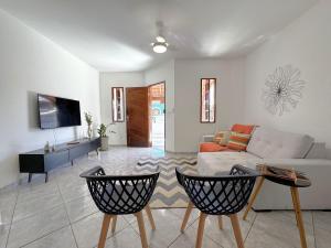 a living room with a couch and a tv at Duplex lindo a 200m da praia | ROTO162 in Rio das Ostras