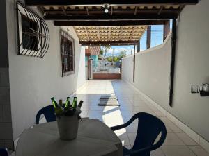 a table and chairs in a room with a view of a patio at Duplex lindo a 200m da praia | ROTO162 in Rio das Ostras