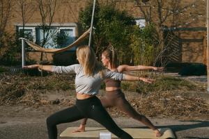 Zwei Frauen machen Yoga auf einem Surfbrett. in der Unterkunft DE BUITENKANS urban camping - unique cabins in Rotterdam + 57 Fotos