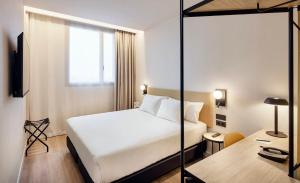 una habitación de hotel con una cama y un escritorio en Sercotel Barcelona El Prat, en El Prat de Llobregat