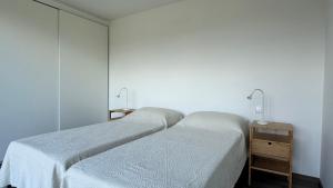 a bedroom with two beds and a night stand with two lamps at LAZY HIKERS by Nature Bliss in São Luis